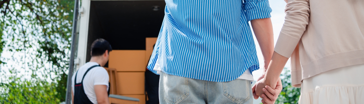 Couple holding hands while overseeing their moving process, assisted by I Love Moving professionals.